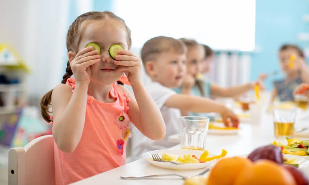 kids eating healthy food in kindergarten Funny kid eating healthy food in kindergarten or daycare